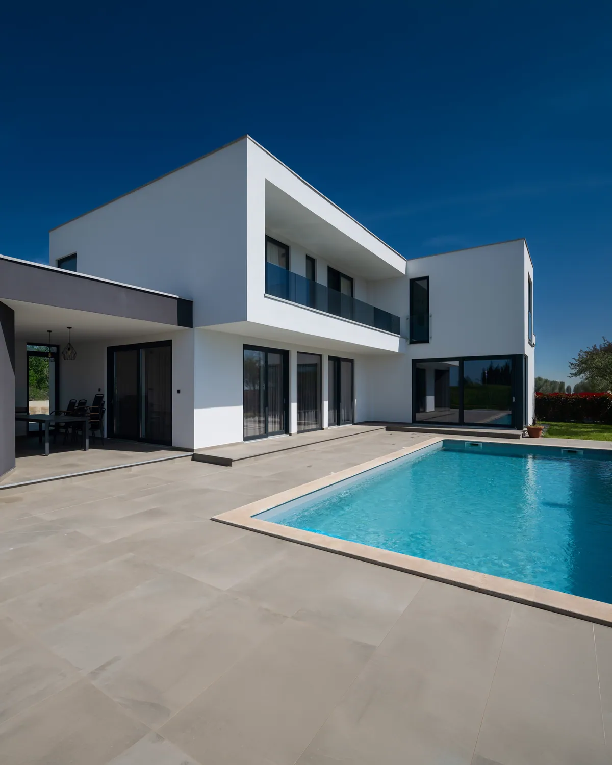 Witte villa met grote schuiframen aan het zwembad